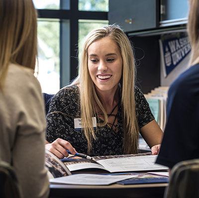 An admissions counselor meets with a prospective student and parents, a part of most of Washburn's campus visits